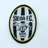 Toppa ufficiale del Siena FC con logo Robur 1904 su sfondo bianco.